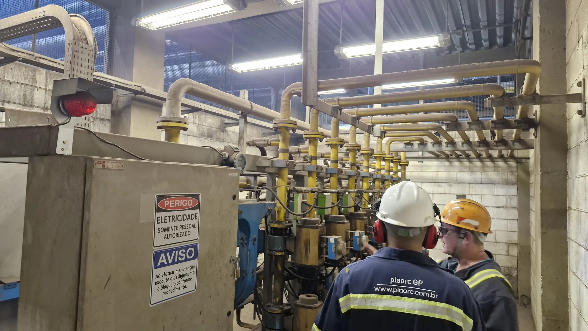 Inspeção de segurança em área industrial com sinalização de risco