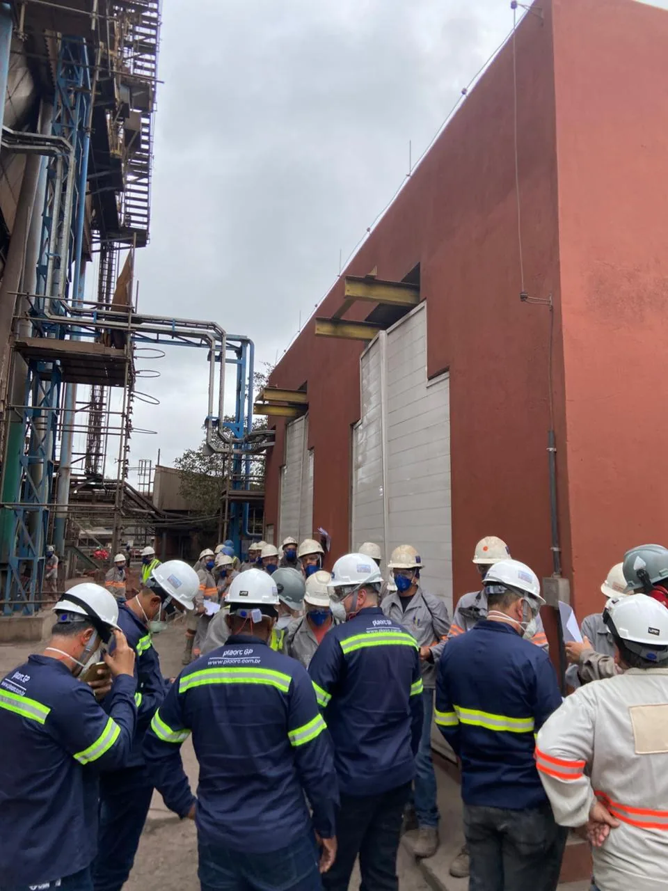 Equipe da PLAORC em visita técnica diante de uma planta industrial